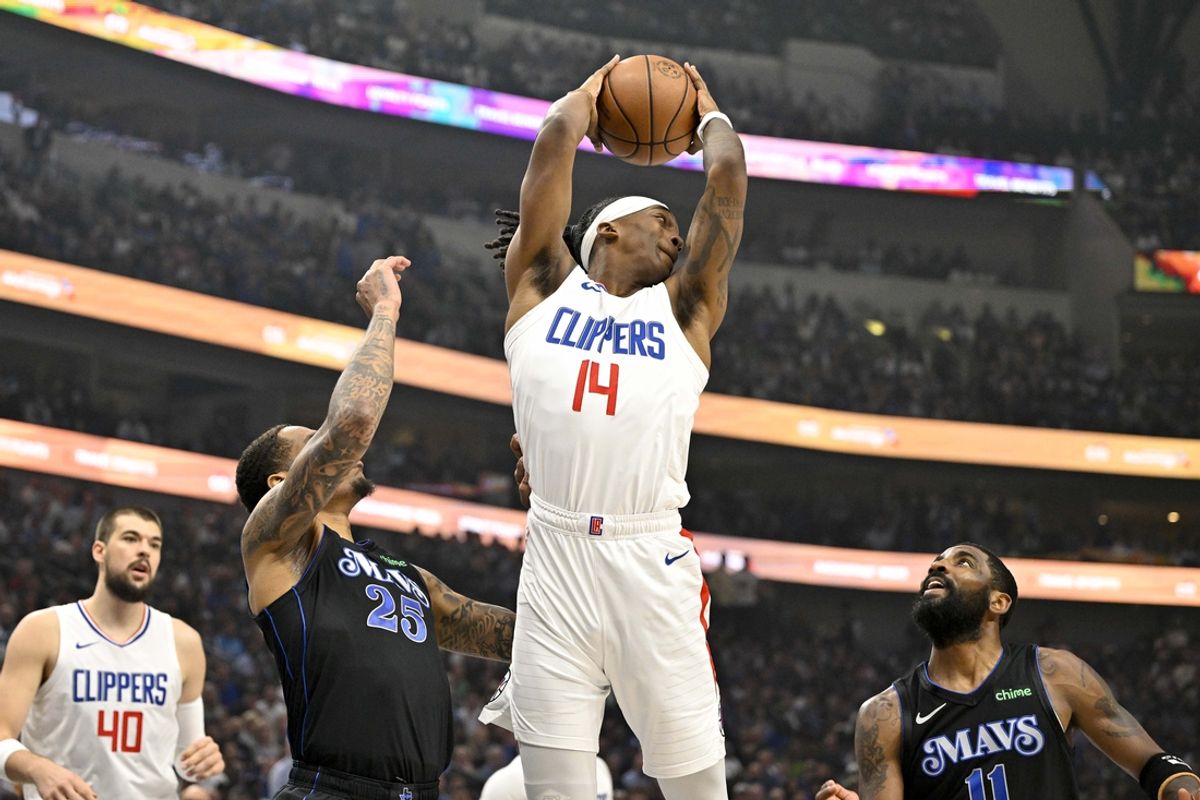 May 3, 2024; Dallas, Texas, USA; LA Clippers guard Terance Mann (14) grabs a rebound over Dallas Mavericks forward P.J. Washington (25) and guard Kyrie Irving (11) during the first quarter during game six of the first round for the 2024 NBA playoffs at American Airlines Center. Mandatory Credit: Jerome Miron-Imagn Images