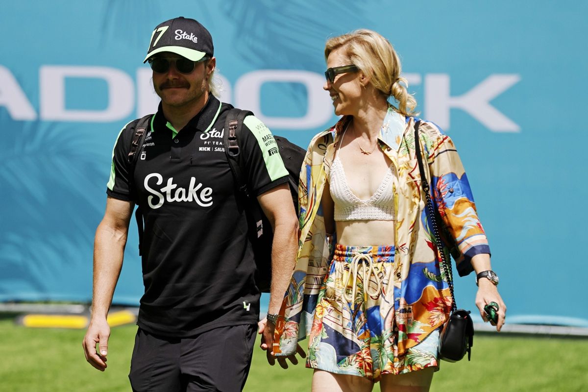 May 5, 2024; Miami Gardens, Florida, USA; Kick Sauber driver Valtteri Bottas (77) walks into the F1 Village with his girlfriend Tiffany Cromwell before the F1 Miami Grand Prix at Miami International Autodrome. Mandatory Credit: Peter Casey-Imagn Images
