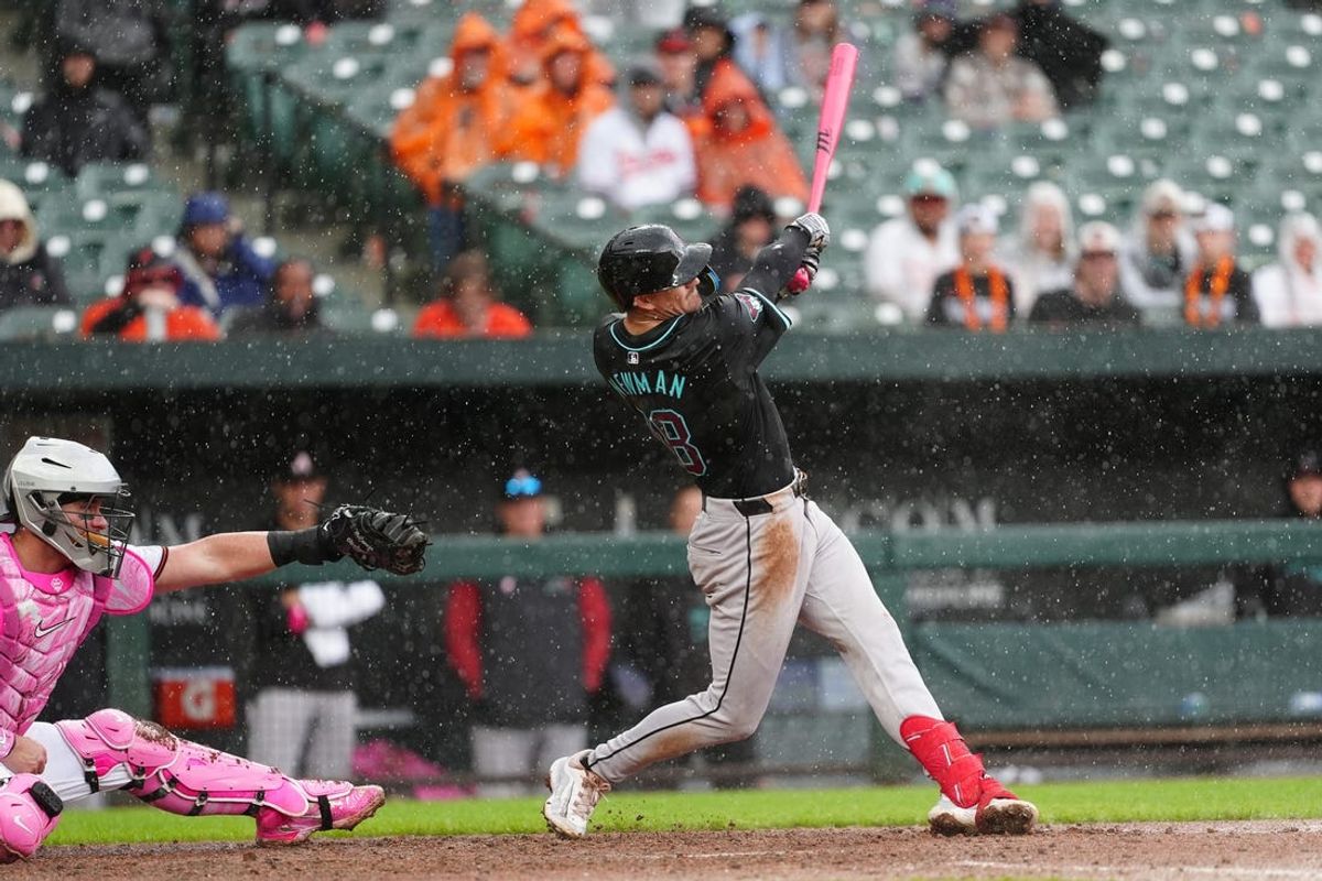 May 12, 2024; Baltimore, Maryland, USA; Arizona Diamondbacks shortstop Kevin Newman (18) hits a double against the Baltimore Orioles during the seventh inning at Oriole Park at Camden Yards. Mandatory Credit: Gregory Fisher-USA TODAY Sports