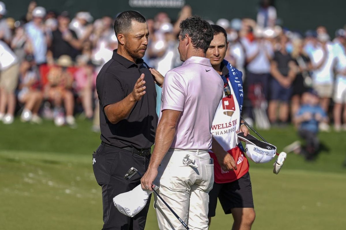 May 12, 2024; Charlotte, North Carolina, USA; Rory McIlroy and Xander Schauffele shake hands at the end of the final round of the Wells Fargo Championship golf tournament. Mandatory Credit: Jim Dedmon-USA TODAY Sports