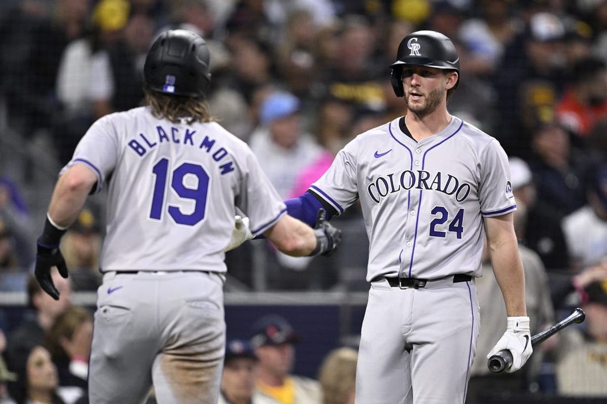 May 13, 2024; San Diego, California, USA; Colorado Rockies designated hitter Charlie Blackmon (19) is congratulated by third baseman Ryan McMahon (24) after scoring a run against the San Diego Padres during the fourth inning at Petco Park. Mandatory Credit: Orlando Ramirez-USA TODAY Sports