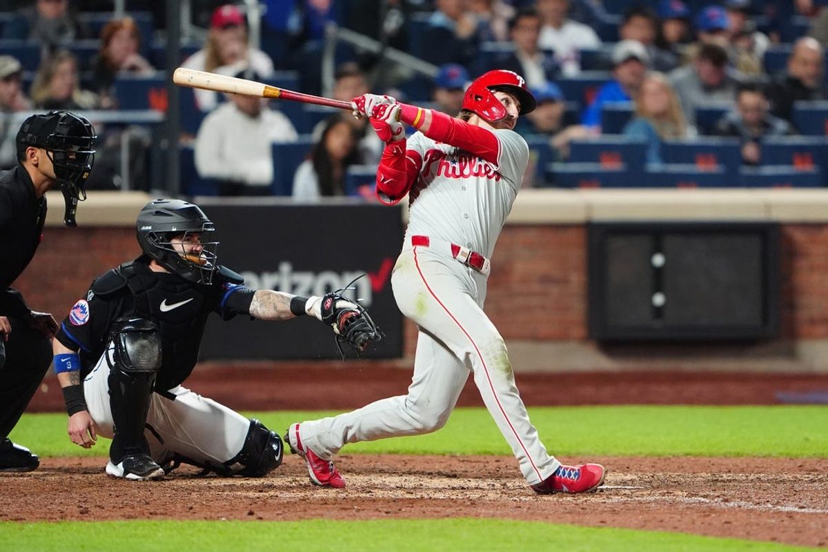 May 13, 2024; New York City, New York, USA; Philadelphia Phillies second baseman Bryson Stott (5) hits a sacrifice fly ball to drive in a run against the New York Mets during the tenth inning at Citi Field. Mandatory Credit: Gregory Fisher-USA TODAY Sports