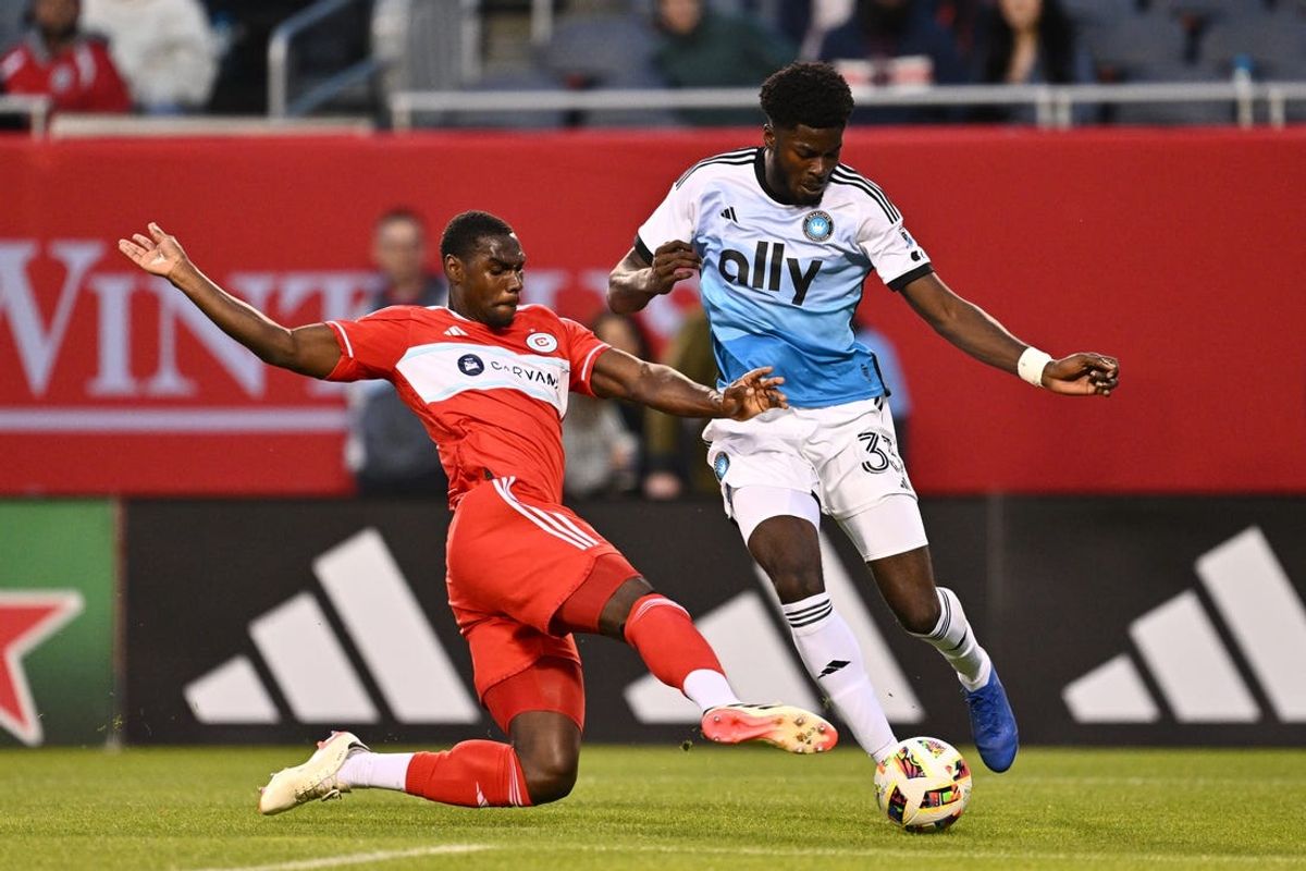 May 15, 2024; Chicago, Illinois, USA; Charlotte FC forward Patrick Agyemang (33) dribbles as Chicago Fire FC defender Carlos Teran (4) defends during the first half at Soldier Field. Mandatory Credit: Jamie Sabau-USA TODAY Sports