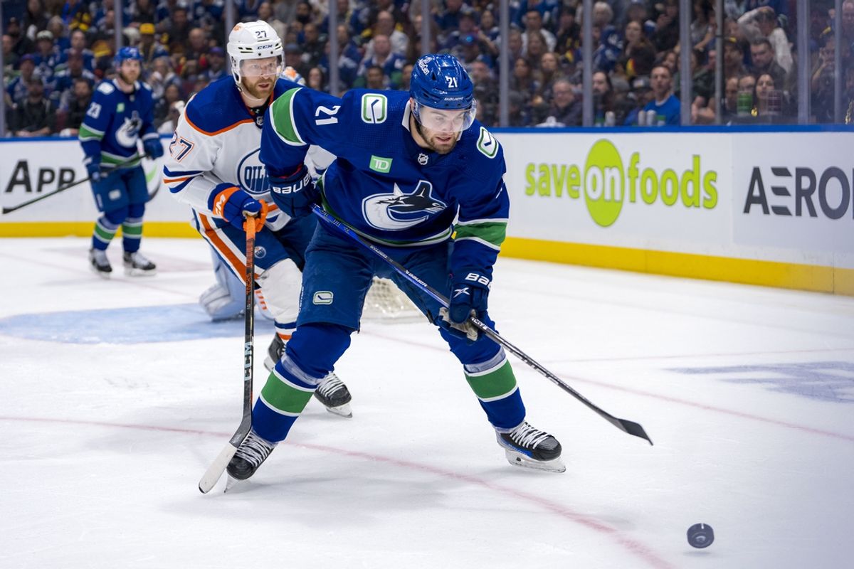 May 16, 2024; Vancouver, British Columbia, CAN; Edmonton Oilers defenseman Brett Kulak (27) watches Vancouver Canucks forward Nils Hoglander (21) handles the puck during the third period in game five of the second round of the 2024 Stanley Cup Playoffs at Rogers Arena. Mandatory Credit: Bob Frid-Imagn Images