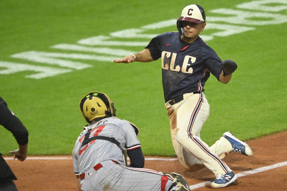 May 17, 2024; Cleveland, Ohio, USA; Cleveland Guardians second baseman Andres Gimenez (0) slides before being tagged out by Minnesota Twins catcher Ryan Jeffers (27) in the sixth inning at Progressive Field. Mandatory Credit: David Richard-USA TODAY Sports