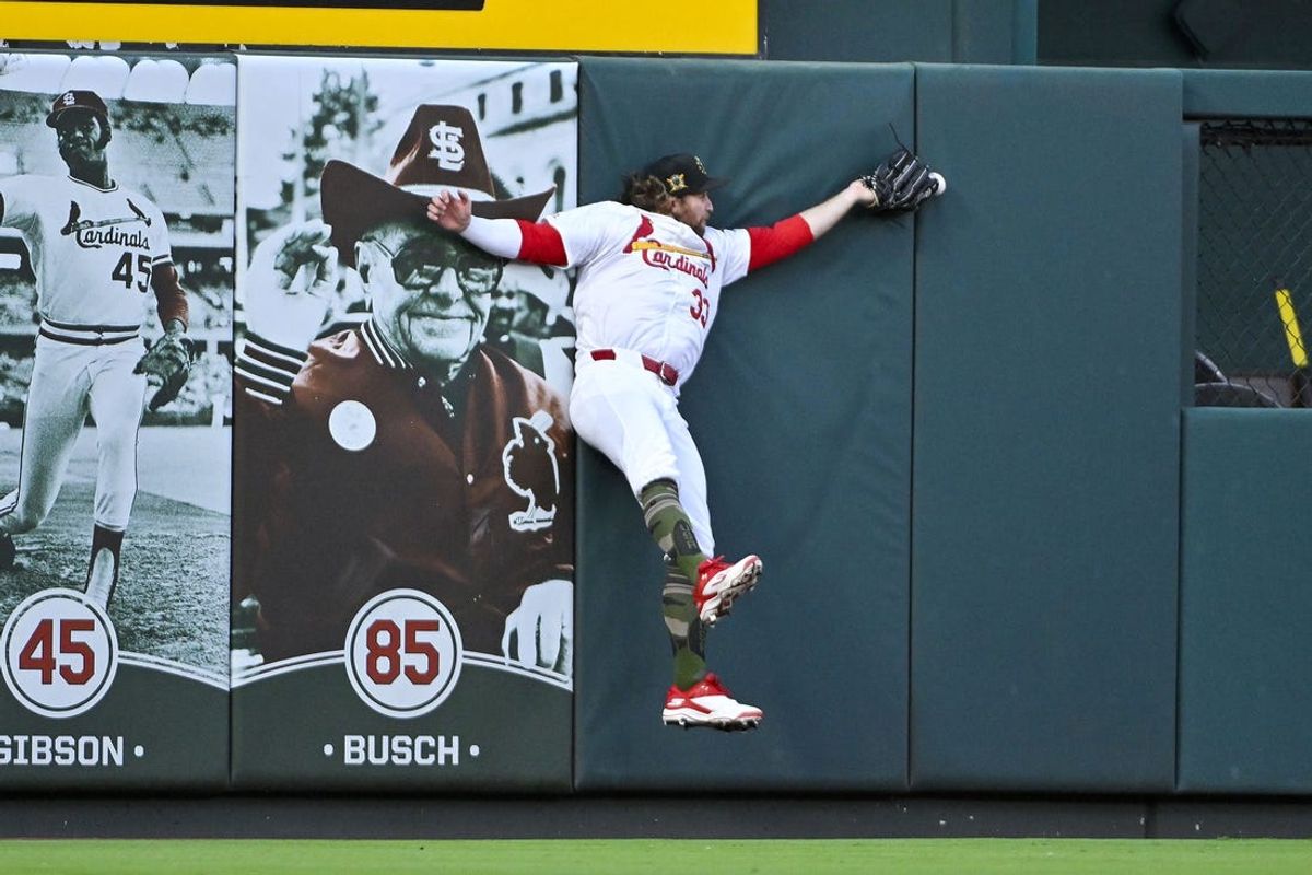 May 17, 2024; St. Louis, Missouri, USA;  St. Louis Cardinals left fielder Brendan Donovan (33) leaps at the wall but is unable to catch a double hit by Boston Red Sox first baseman Dominic Smith (not pictured) during the second inning at Busch Stadium. Mandatory Credit: Jeff Curry-USA TODAY Sports