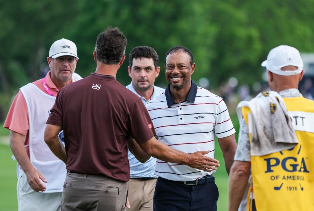 Tiger Woods smiles after finishing his round of golf with golfers Adam Scott and Keegan Bradley at the 18th green late Friday at the 2024 PGA Championship second round at Valhalla Golf Course in Louisville, Kentucky. May 17, 2024. The 15-time major champion Woods missed the cut -- finishing 72 and 77 for his two rounds.