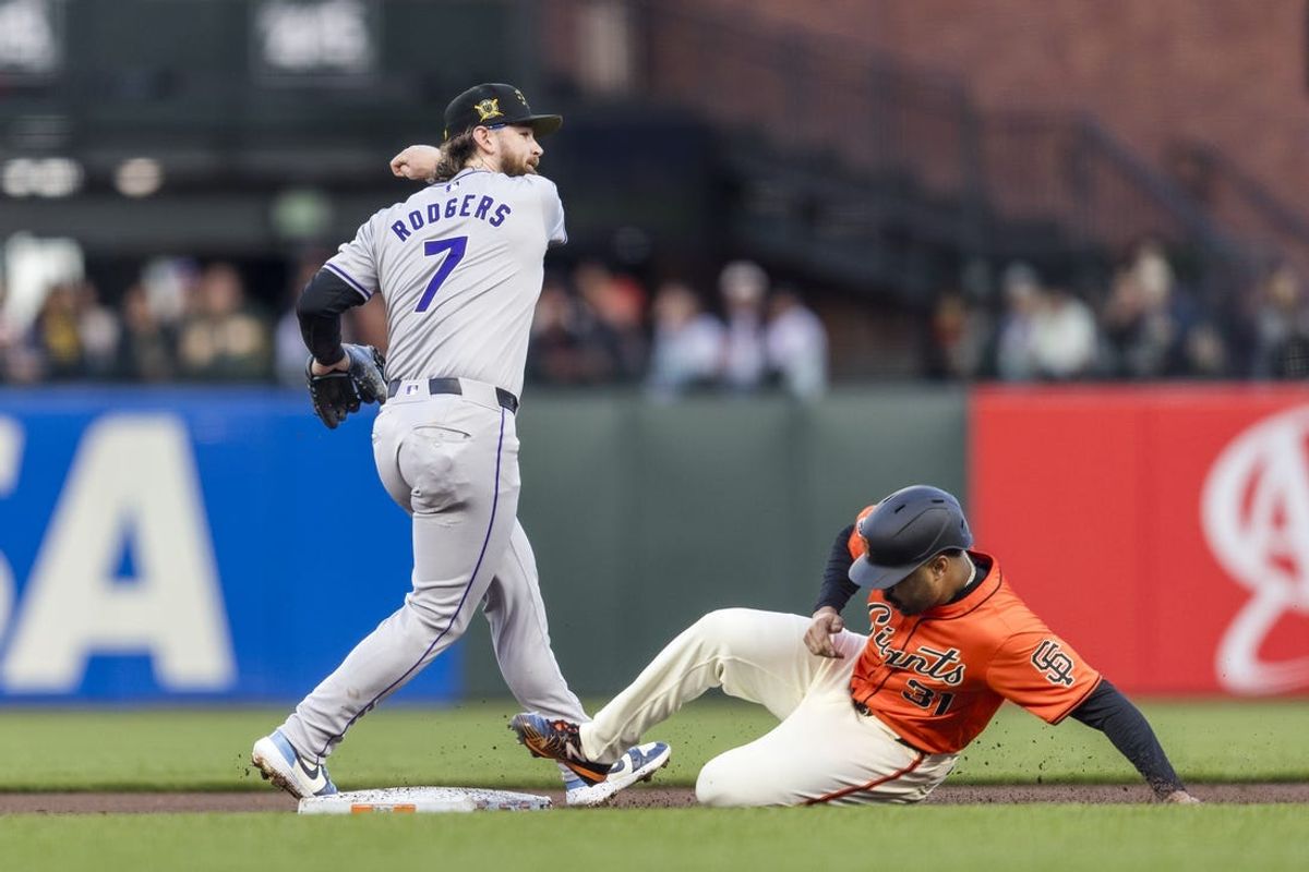 May 17, 2024; San Francisco, California, USA; San Francisco Giants first baseman LaMonte Wade Jr. (31) is out as Colorado Rockies second baseman Brendan Rodgers (7) throws too late for a double play during the first inning at Oracle Park. Mandatory Credit: John Hefti-USA TODAY Sports