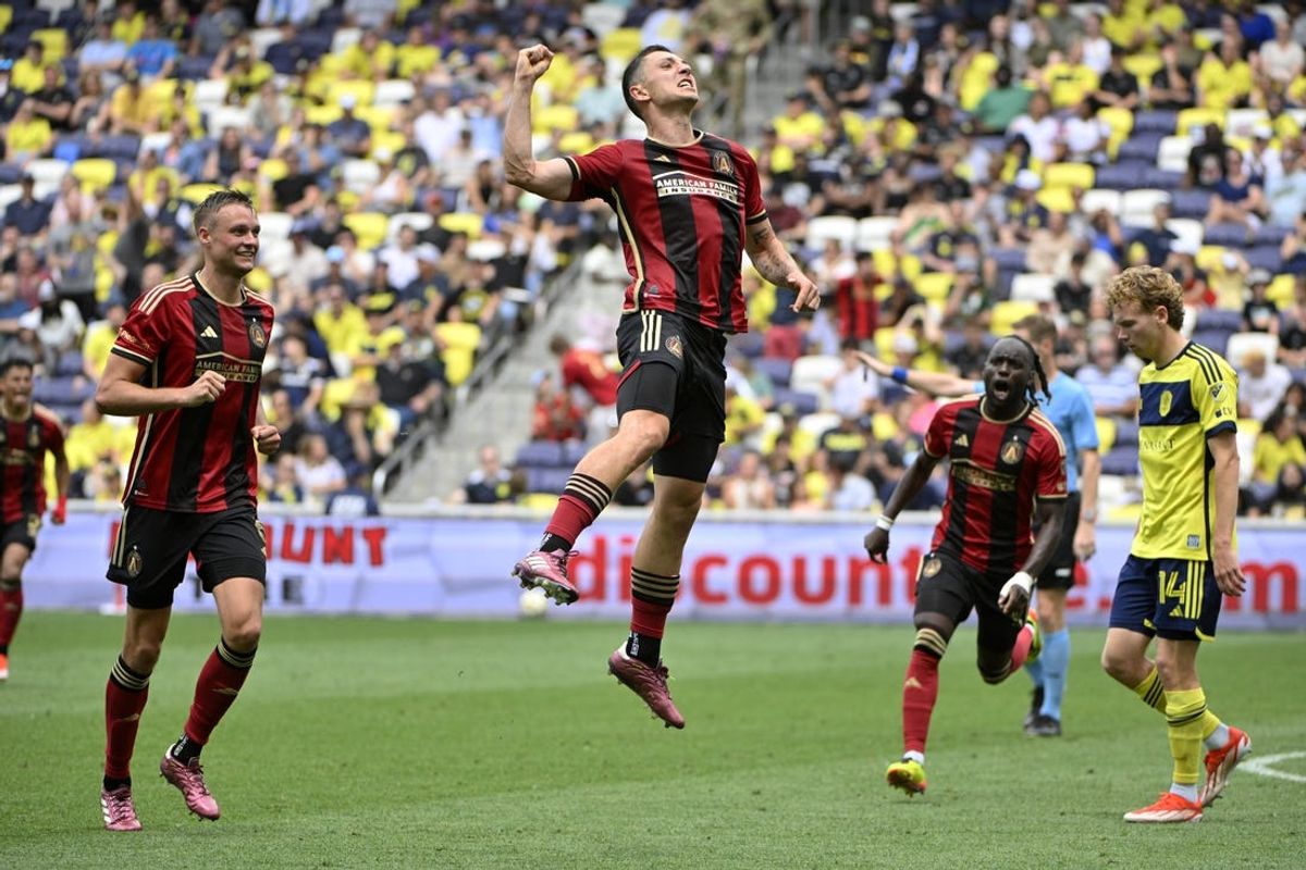 May 18, 2024; Nashville, Tennessee, USA; Atlanta United midfielder Bartosz Slisz (middle) celebrates with defender Stian Gregersen (5) and midfielder Tristan Muyumba (8) after scoring a goal against Nashville SC during the second half at Geodis Park. Mandatory Credit: Steve Roberts-USA TODAY Sports