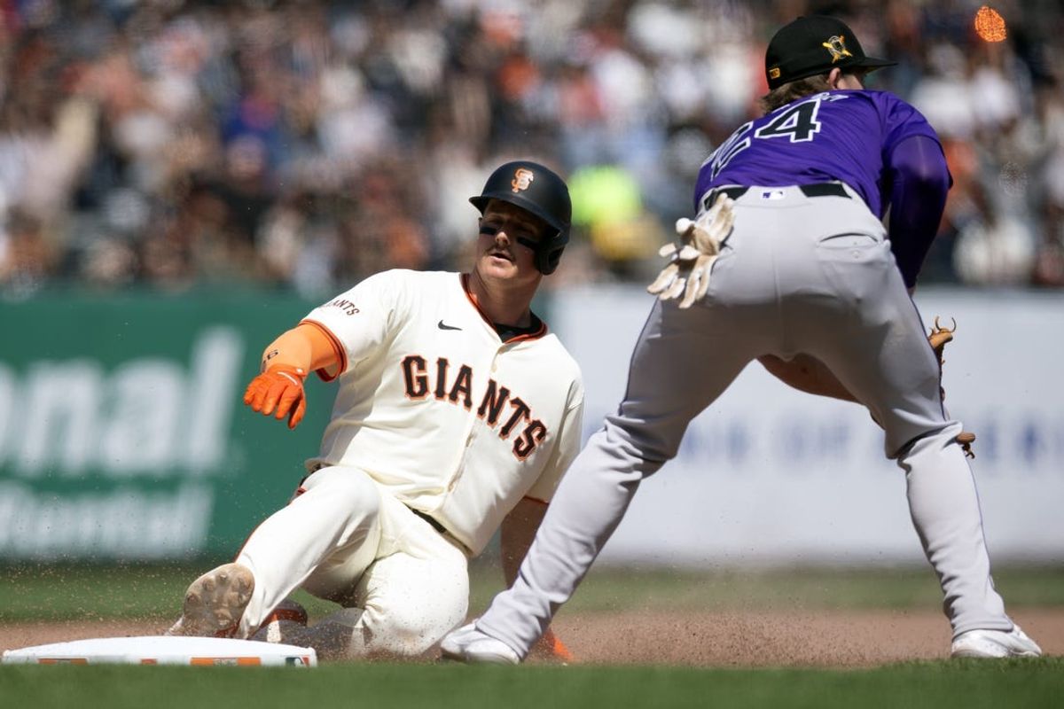May 18, 2024; San Francisco, California, USA; San Francisco Giants third baseman Matt Chapman (26) slides safely into third base ahead of the relay to Colorado Rockies third baseman Ryan McMahon (24) on a double and an error during the seventh inning at Oracle Park. Mandatory Credit: D. Ross Cameron-USA TODAY Sports