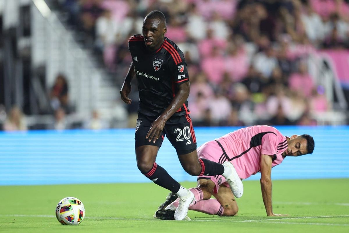 May 18, 2024; Fort Lauderdale, Florida, USA; D.C. United forward Christian Benteke (20) and Inter Miami CF defender Sergio Busquets (5) battle for the ball in the first half at Chase Stadium. Mandatory Credit: Nathan Ray Seebeck-USA TODAY Sports