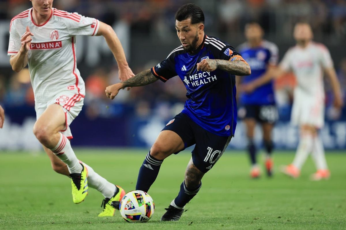 May 18, 2024; Cincinnati, Ohio, USA; FC Cincinnati midfielder Luciano Acosta (10) dribbles the ball against St. Louis CITY SC midfielder Chris Durkin (8) during the second half at TQL Stadium. Mandatory Credit: Katie Stratman-USA TODAY Sports