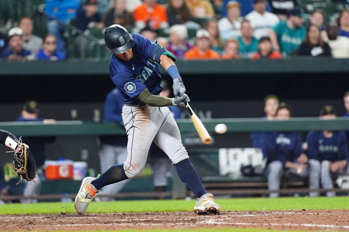 May 18, 2024; Baltimore, Maryland, USA; Seattle Mariners shortstop Dylan Moore (25) hits an RBI double against the Baltimore Orioles during the eighth inning at Oriole Park at Camden Yards. Mandatory Credit: Gregory Fisher-USA TODAY Sports