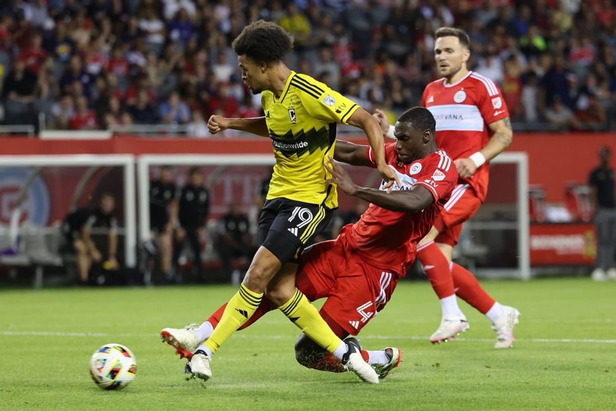 May 18, 2024; Chicago, Illinois, USA; Chicago Fire FC defender Carlos Teran (4) slide tackles Columbus Crew forward Jacen Russell-Rowe (19) during the second half at Soldier Field. Mandatory Credit: Mike Dinovo-USA TODAY Sports