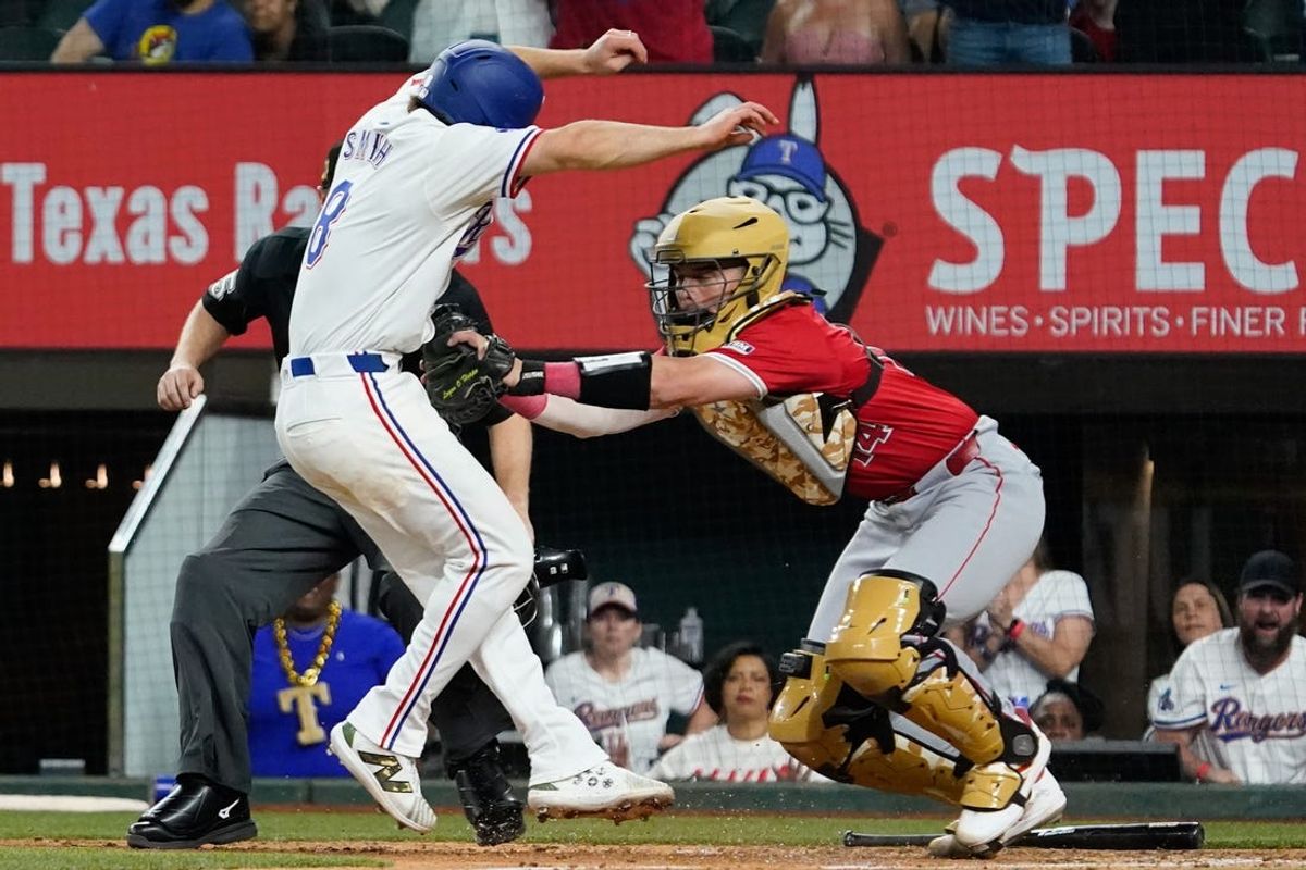 May 18, 2024; Arlington, Texas, USA; Texas Rangers third baseman Josh Smith (8) is tagged out at the plate by Los Angeles Angels catcher Logan O'Hoppe (14) during the tenth inning at Globe Life Field. Mandatory Credit: Raymond Carlin III-USA TODAY Sports