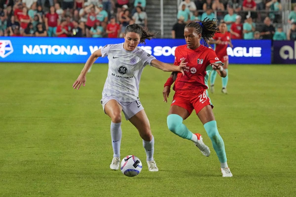 May 18, 2024; Kansas City, Missouri, USA; Racing Louisville FC forward Emma Sears (13) controls the ball as Kansas City Current defender Gabrielle Robinson (24) defends during the second half at CPKC Stadium. Mandatory Credit: Denny Medley-USA TODAY Sports