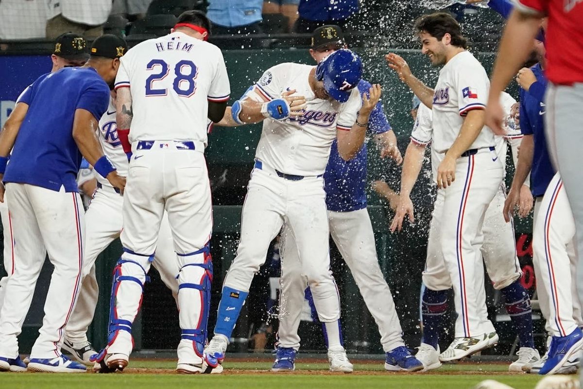 May 18, 2024; Arlington, Texas, USA; Teammates celebrate with Texas Rangers first baseman Nathaniel Lowe (30), who was hit by a pitch with the bases load during the thirteenth inning against the Los Angeles Angels to win the game 3-2 at Globe Life Field. Mandatory Credit: Raymond Carlin III-USA TODAY Sports