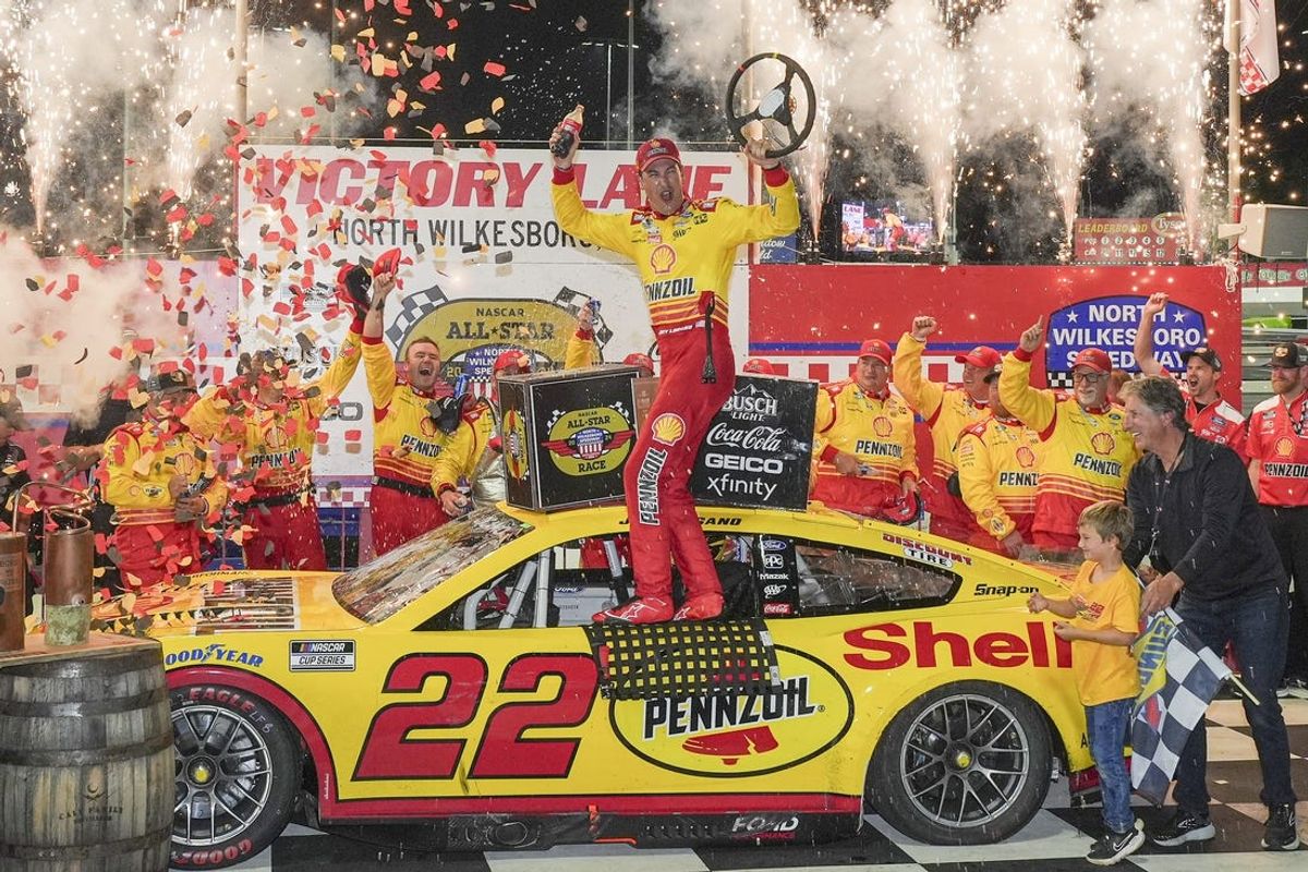 May 19, 2024; North Wilkesboro, North Carolina, USA;  NASCAR Cup Series driver Joey Logano (22) celebrates his win with his team during the All Star race at North Wilkesboro Speedway. Mandatory Credit: Jim Dedmon-USA TODAY Sports
