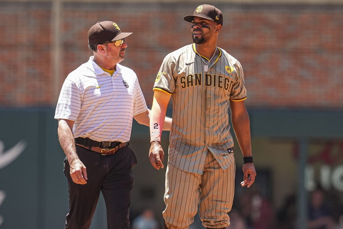 May 20, 2024; Cumberland, Georgia, USA; San Diego Padres second baseman Xander Bogaerts (2) is helped by the trainer as he leaves the game after being injured against the Atlanta Braves during the third inning at Truist Park. Mandatory Credit: Dale Zanine-USA TODAY Sports