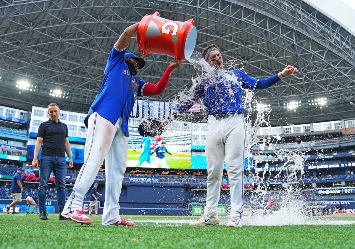 May 20, 2024; Toronto, Ontario, CAN; Toronto Blue Jays first base Vladimir Guerrero Jr. (27) pours the water bucket on catcher Danny Jansen (9) against the Chicago White Sox at the end of the ninth inning at Rogers Centre. Mandatory Credit: Nick Turchiaro-USA TODAY Sports