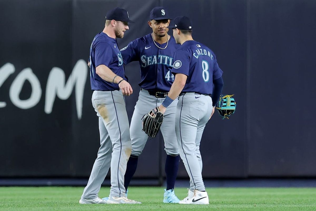 May 20, 2024; Bronx, New York, USA; Seattle Mariners left fielder Luke Raley (20) and center fielder Julio Rodriguez (44) and right fielder Dominic Canzone (8) celebrate after defeating the New York Yankees at Yankee Stadium. Mandatory Credit: Brad Penner-USA TODAY Sports