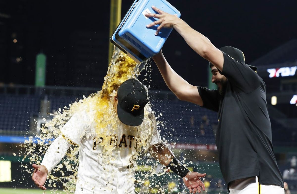 May 21, 2024; Pittsburgh, Pennsylvania, USA;  Pittsburgh Pirates starting pitcher Martín Pérez (right) pours Powerade on second baseman Nick Gonzales (left) after Gonzales hit a game winning walk off single against the San Francisco Giants during the tenth inning at PNC Park. Pittsburgh won 7-6 in ten innings. Mandatory Credit: Charles LeClaire-USA TODAY Sports