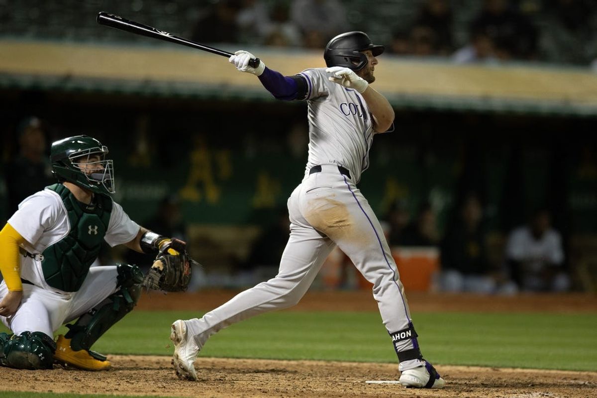 May 22, 2024; Oakland, California, USA; Colorado Rockies third baseman Ryan McMahon (24) follows the flight of his two-run home run against the Oakland Athletics during the 12th inning at Oakland-Alameda County Coliseum. Athletics catcher is Shea Langeliers. Mandatory Credit: D. Ross Cameron-USA TODAY Sports