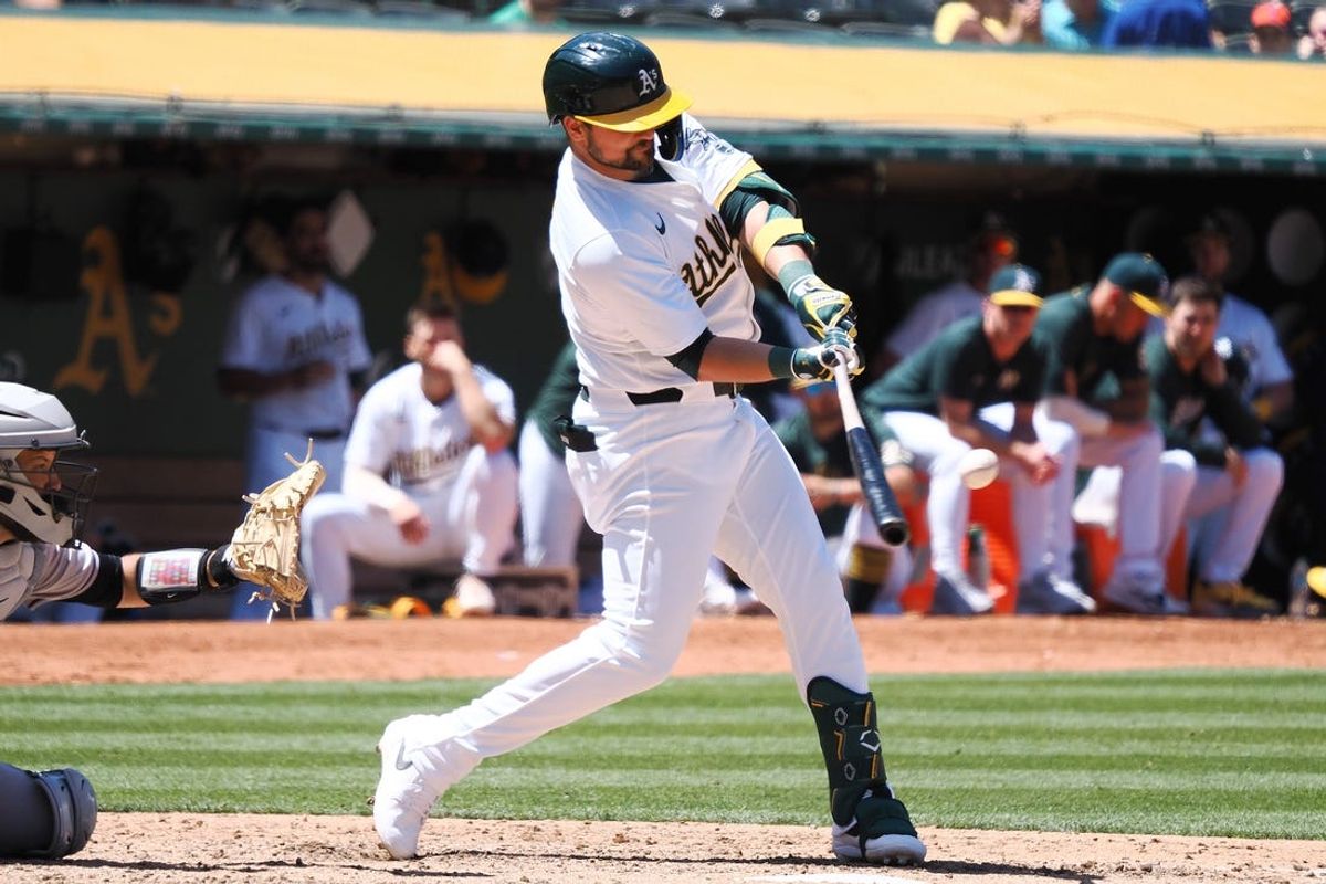 May 23, 2024; Oakland, California, USA; Oakland Athletics first baseman J.D. Davis (5) hits a two-run home run against the Colorado Rockies during the eighth inning at Oakland-Alameda County Coliseum. Mandatory Credit: Kelley L Cox-USA TODAY Sports