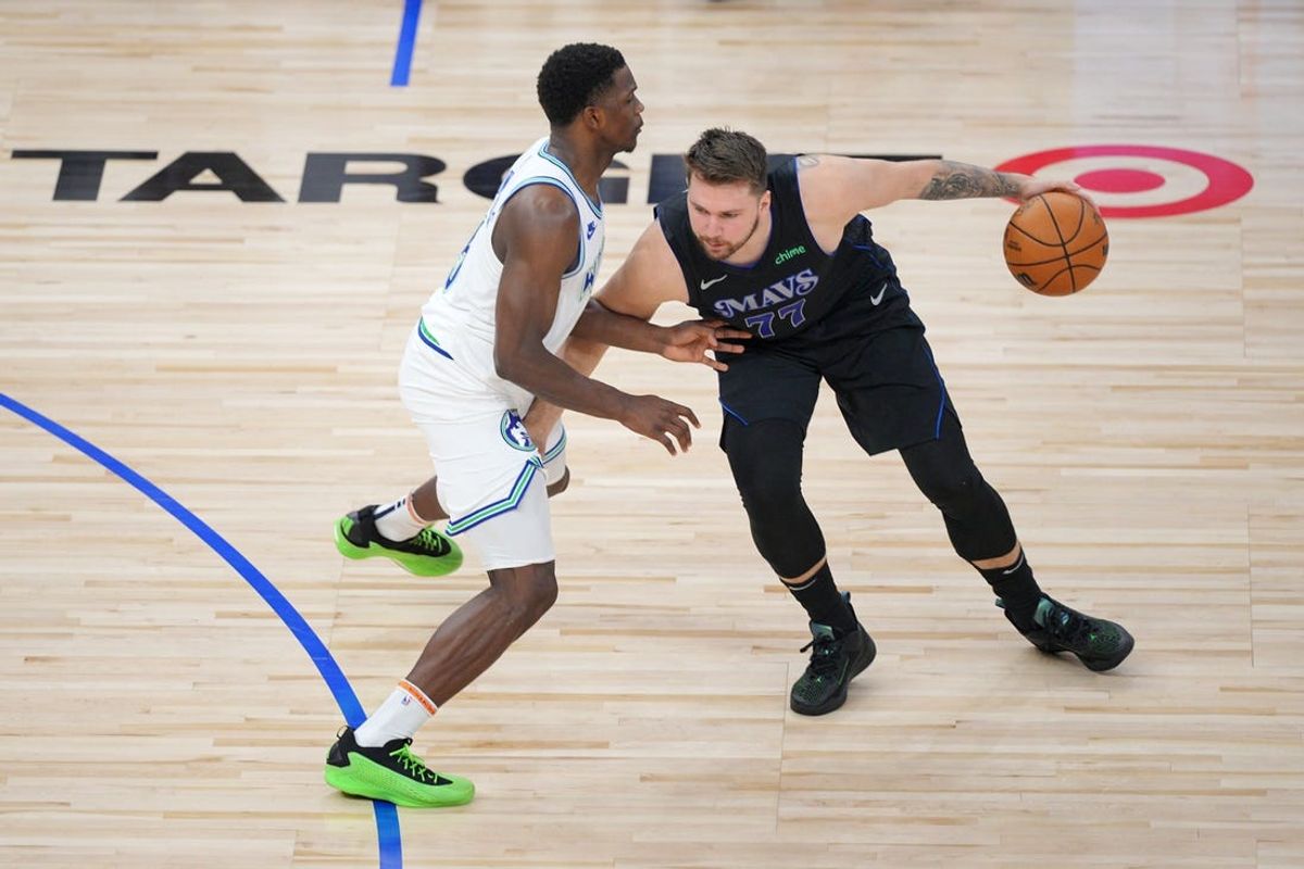 May 24, 2024; Minneapolis, Minnesota, USA; Dallas Mavericks guard Luka Doncic (77) controls the ball against Minnesota Timberwolves guard Anthony Edwards (5) in the first quarter during game two of the western conference finals for the 2024 NBA playoffs at Target Center. Mandatory Credit: Brad Rempel-USA TODAY Sports