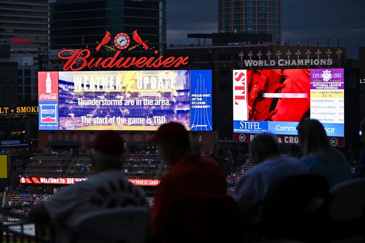 May 24, 2024; St. Louis, Missouri, USA;  Fans look on from under an overhang during a weather delay before a game between the St. Louis Cardinals and the Chicago Cubs at Busch Stadium. Mandatory Credit: Jeff Curry-USA TODAY Sports