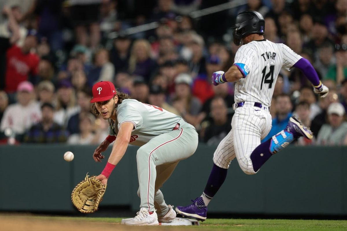 May 24, 2024; Denver, Colorado, USA; Colorado Rockies shortstop Ezequiel Tovar (14) reaches first ahead of a throw to Philadelphia Phillies first baseman Alec Bohm (28) in the ninth inning at Coors Field. Mandatory Credit: Isaiah J. Downing-USA TODAY Sports