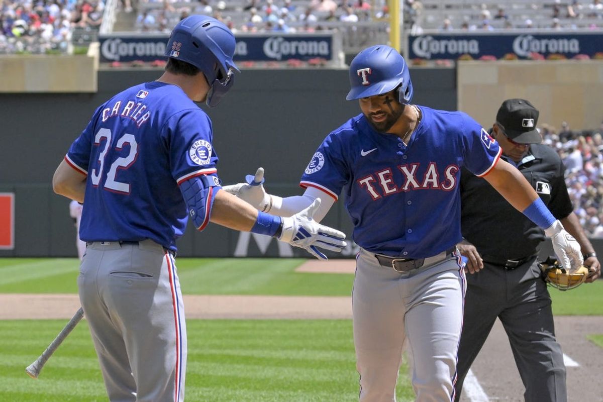 May 25, 2024; Minneapolis, Minnesota, USA;  Texas Rangers outfielder Ezequiel Duran (20) celebrates his solo home run against the Minnesota Twins with outfielder Evan Carter (32) during the fifth inning at Target Field. Mandatory Credit: Nick Wosika-USA TODAY Sports