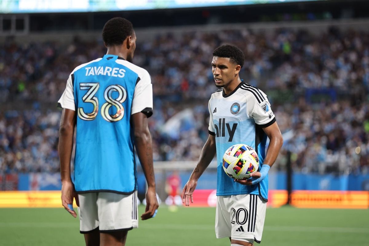 May 25, 2024; Charlotte, North Carolina, USA; Charlotte FC defender Joao Pedro (20) and forward Iuri Tavares (38) talk in the second half against the Philadelphia Union at Bank of America Stadium. Mandatory Credit: Cory Knowlton-Imagn Images