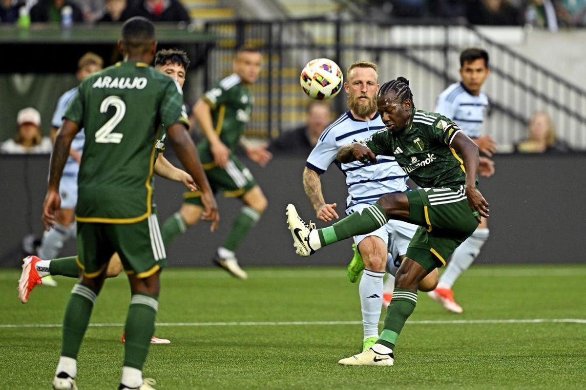 May 25, 2024; Portland, Oregon, USA; Portland Timbers midfielder Diego Chara (21) kicks the ball against Sporting Kansas City forward Johnny Russell (7) during the first half at Providence Park. Mandatory Credit: Troy Wayrynen-USA TODAY Sports