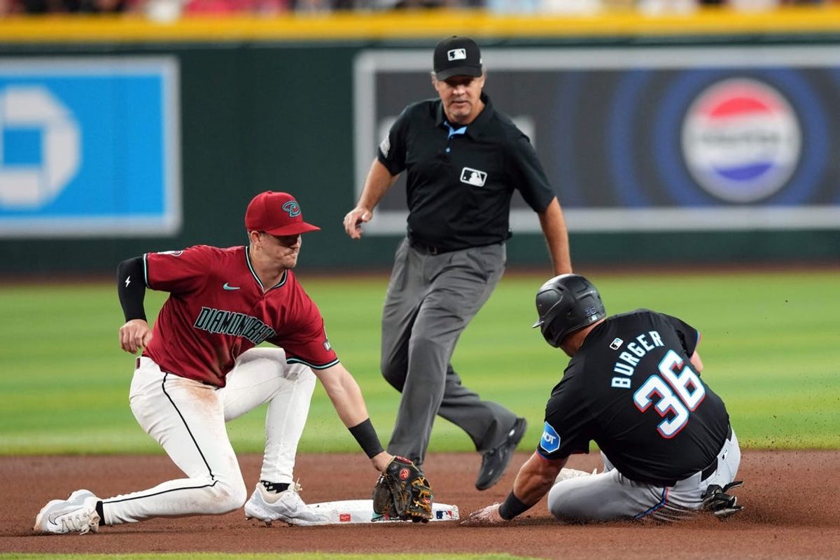 May 25, 2024; Phoenix, Arizona, USA; Arizona Diamondbacks shortstop Blaze Alexander (9) tags out Miami Marlins third base Jake Burger (36) during a steal attempt during the fifth inning at Chase Field. Mandatory Credit: Joe Camporeale-USA TODAY Sports