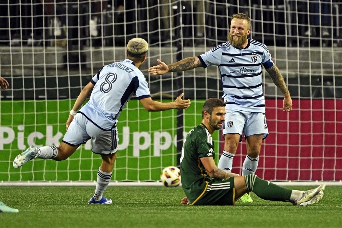 May 25, 2024; Portland, Oregon, USA; Sporting Kansas City midfielder Memo Rodriguez (8) celebrates with forward Johnny Russell (7) after scoring a goal during the second half against the Portland Timbers at Providence Park. Mandatory Credit: Troy Wayrynen-USA TODAY Sports