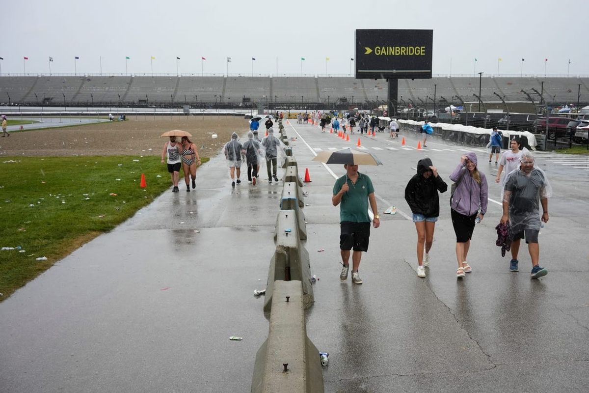 Spectators walk toward the exit after an official evacuation order was issued due to severe weather, Sunday, May 26, 2024, ahead of the 108th running of the Indianapolis 500 at Indianapolis Motor Speedway.