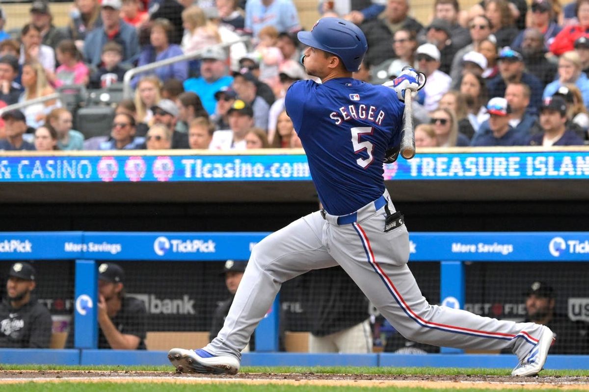May 26, 2024; Minneapolis, Minnesota, USA;  Texas Rangers infielder Corey Seager (5) hits a two-run home run against the Minnesota Twins during the third inning at Target Field. Mandatory Credit: Nick Wosika-USA TODAY Sports