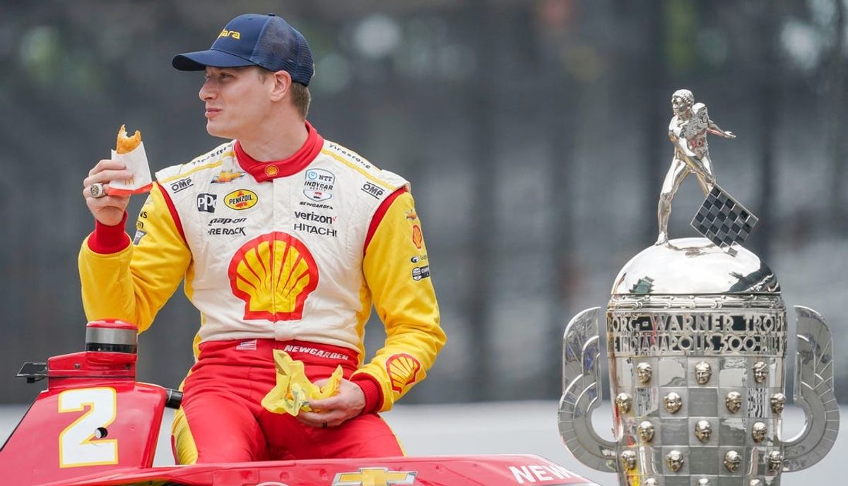 Team Penske driver Josef Newgarden (2) eats a hash brown between portraits Monday, May 27, 2024, after winning the 108th running of the Indianapolis 500 at Indianapolis Motor Speedway.