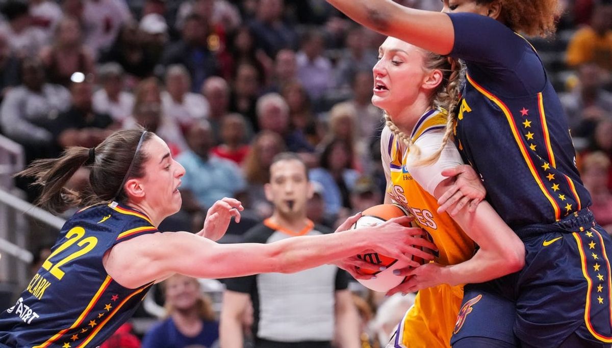 Indiana Fever guard Caitlin Clark (22) reaches for the ball against Los Angeles Sparks forward Cameron Brink (22) on Tuesday, May 28, 2024, during the game at Gainbridge Fieldhouse in Indianapolis.