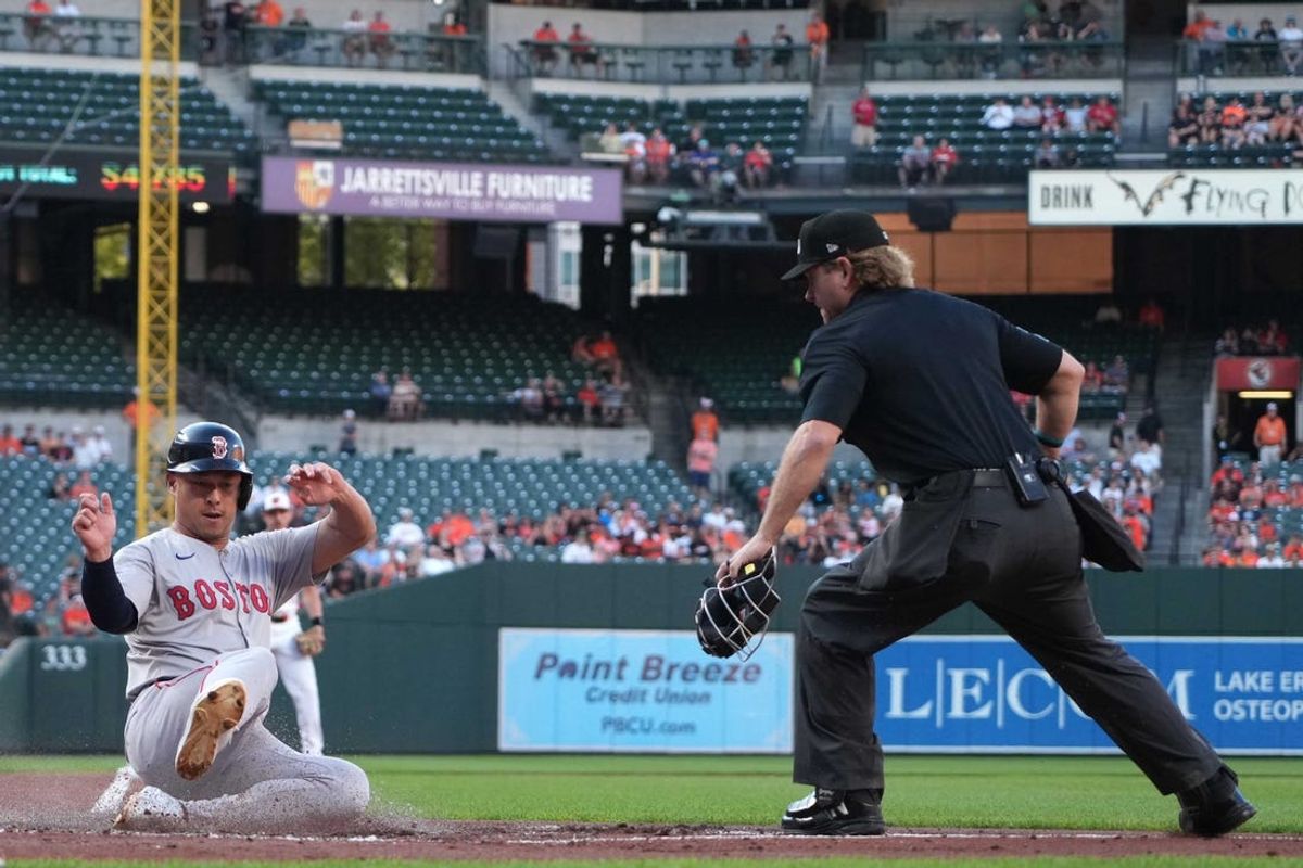 May 28, 2024; Baltimore, Maryland, USA; Boston Red Sox outfielder Rob Refsnyder (30) scores during the first inning in front of umpire Mike Muchlinski against the Baltimore Orioles at Oriole Park at Camden Yards. Mandatory Credit: Mitch Stringer-USA TODAY Sports