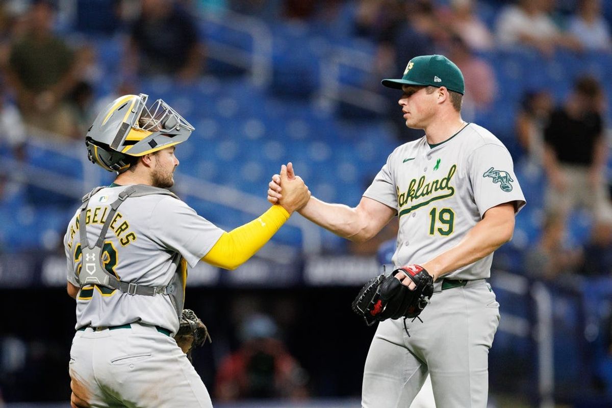 May 28, 2024; St. Petersburg, Florida, USA;  Oakland Athletics pitcher Mason Miller (19) and Oakland Athletics catcher Shea Langeliers (23) celebrate after beating the Tampa Bay Rays at Tropicana Field. Mandatory Credit: Nathan Ray Seebeck-USA TODAY Sports