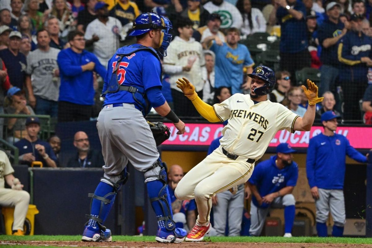 May 29, 2024; Milwaukee, Wisconsin, USA; Milwaukee Brewers shortstop Willy Adames (27) scores a run as Chicago Cubs catcher Yan Gomes (15) looks on in the third inning at American Family Field. Mandatory Credit: Benny Sieu-USA TODAY Sports