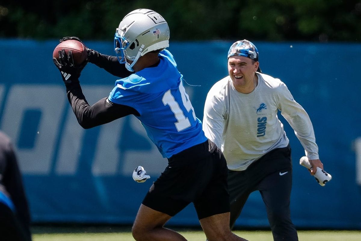Detroit Lions wide receiver Amon-Ra St. Brown (14) practices as assistant wide receivers coach Seth Ryan watches during OTAs at Detroit Lions headquarters and training facility in Allen Park on Thursday, May 30, 2024.