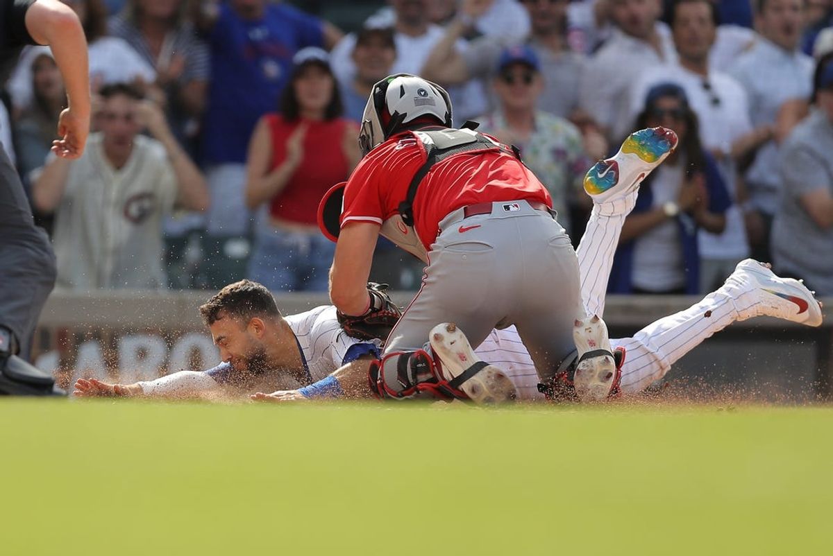 May 31, 2024; Chicago, Illinois, USA; Cincinnati Reds catcher Tyler Stephenson (37) tags out Chicago Cubs third baseman Nick Madrigal (1) as he slides into home plateduring the ninth inning at Wrigley Field. Mandatory Credit: Melissa Tamez-USA TODAY Sports