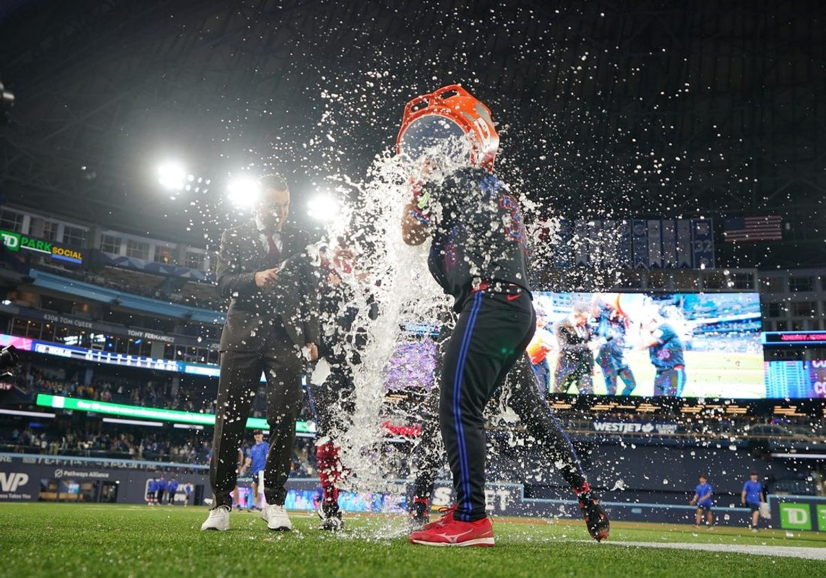 May 31, 2024; Toronto, Ontario, CAN; Toronto Blue Jays first base Vladimir Guerrero Jr. (27) pours the water bucket on Toronto Blue Jays left fielder Davis Schneider (36) after hitting a walk-off home run against the Pittsburgh Pirates during the fourteenth inning at Rogers Centre. Mandatory Credit: Nick Turchiaro-USA TODAY Sports