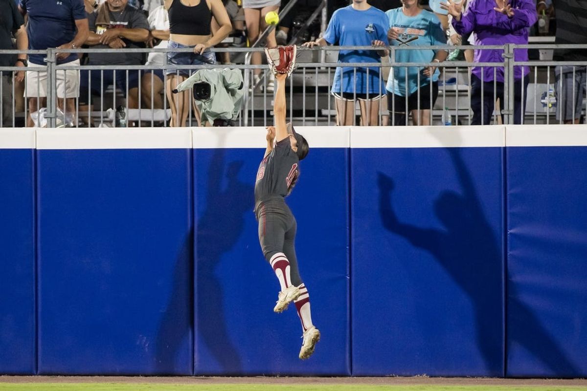 May 31, 2024; Oklahoma City, OK, USA;  Stanford Cardinals outfielder Emily Jones (18) makes a catch at the wall for an out in the fifth inning against the Oklahoma State Cowgirls during a Women's College World Series softball losers bracket elimination game at Devon Park. Mandatory Credit: Brett Rojo-USA TODAY Sports