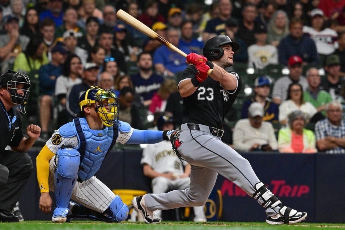 Jun 1, 2024; Milwaukee, Wisconsin, USA; Chicago White Sox left fielder Andrew Benintendi (23) hits a solo home run as Milwaukee Brewers catcher William Contreras (24) looks on in the third inning at American Family Field. Mandatory Credit: Benny Sieu-USA TODAY Sports