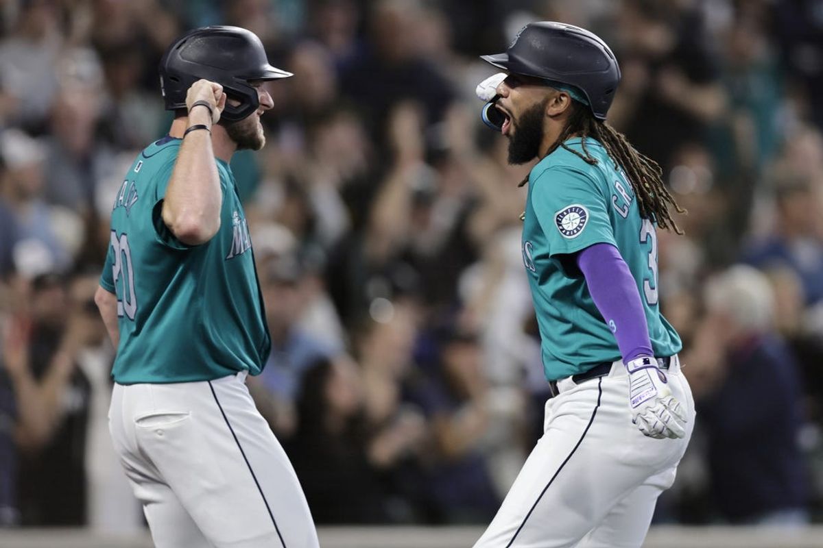 Jun 1, 2024; Seattle, Washington, USA;  Seattle Mariners shortstop J.P. Crawford, right, reacts with Seattle Mariners left fielderer Luke Raley, left, after hitting a grand slam against the Los Angeles Angels during the fourth inning at T-Mobile Park. Mandatory Credit: John Froschauer-USA TODAY Sports