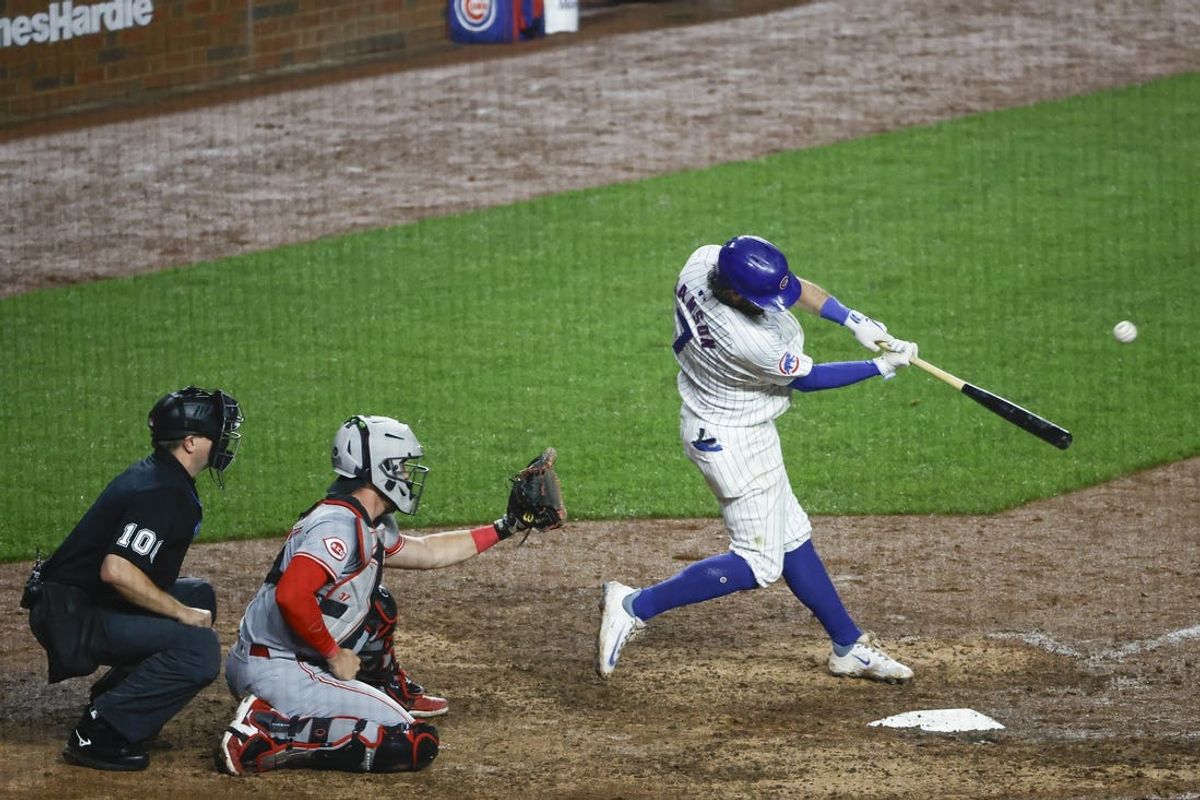 Jun 2, 2024; Chicago, Illinois, USA; Chicago Cubs shortstop Dansby Swanson (7) hits a two-run home run against the Cincinnati Reds during the eight inning at Wrigley Field. Mandatory Credit: Kamil Krzaczynski-USA TODAY Sports